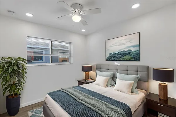 a bedroom with bed and a potted plant