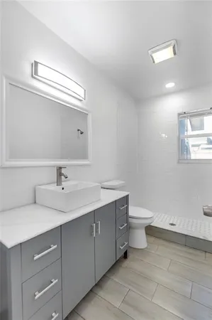 a bathroom with a toilet sink and mirror