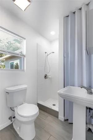 a bathroom with a toilet a sink and shower