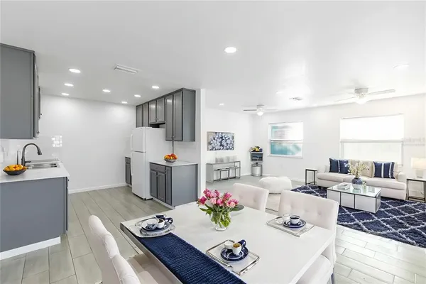 a living room with furniture kitchen view and a chandelier