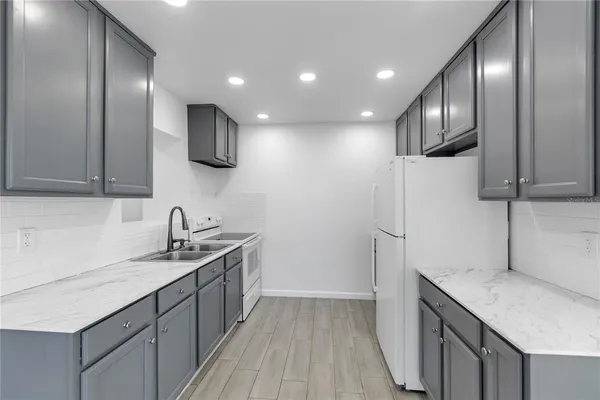 a kitchen with stainless steel appliances granite countertop a sink stove and refrigerator