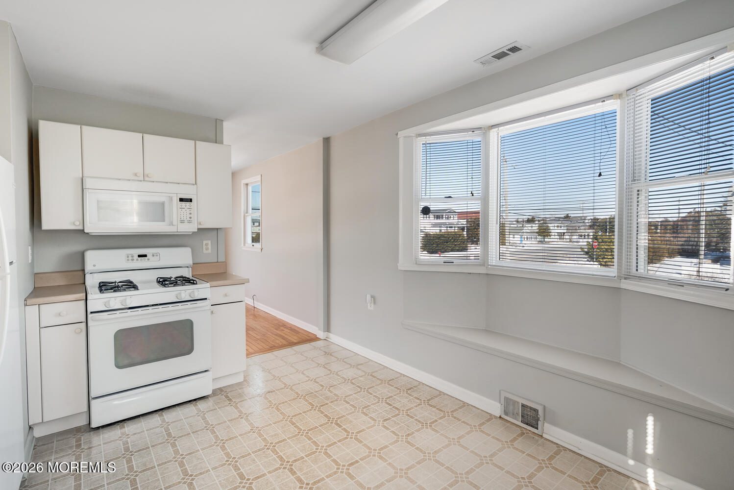 2402 R Central Avenue Barnegat Light, NJ 08006 - Photo 7 of 27 a kitchen with white cabinets and a stove top oven