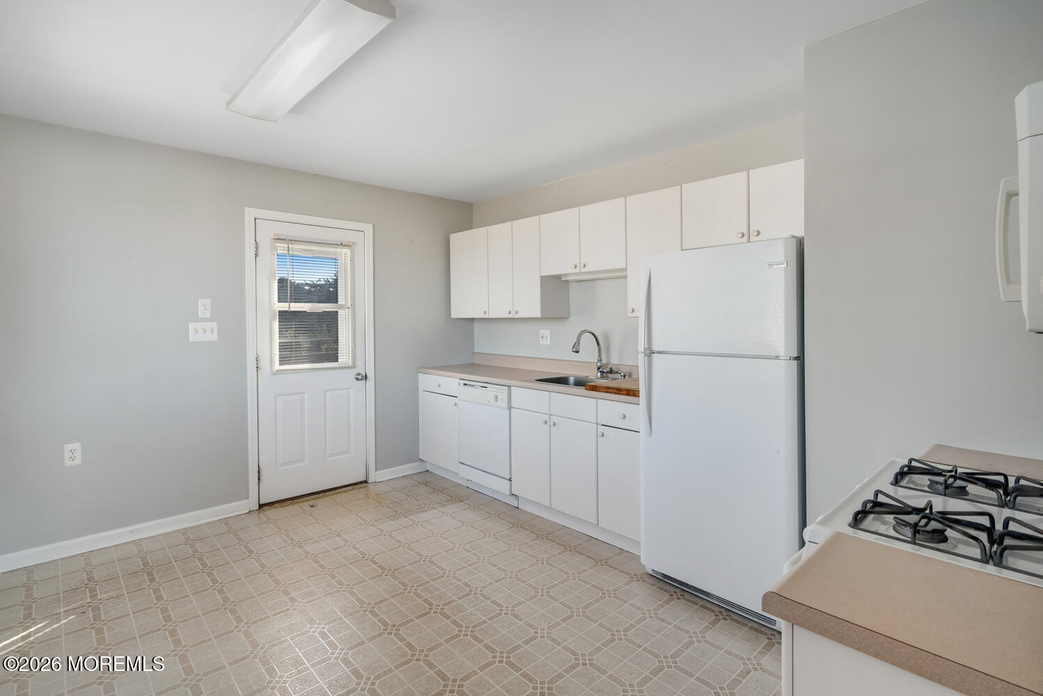 2402 R Central Avenue Barnegat Light, NJ 08006 - Photo 8 of 27 a kitchen with white cabinets and white appliances