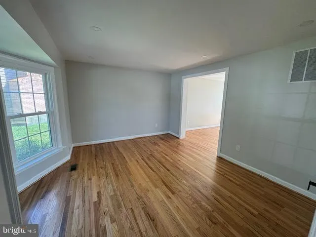 wooden floor in an empty room with a window