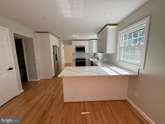 a view of kitchen with sink refrigerator and window