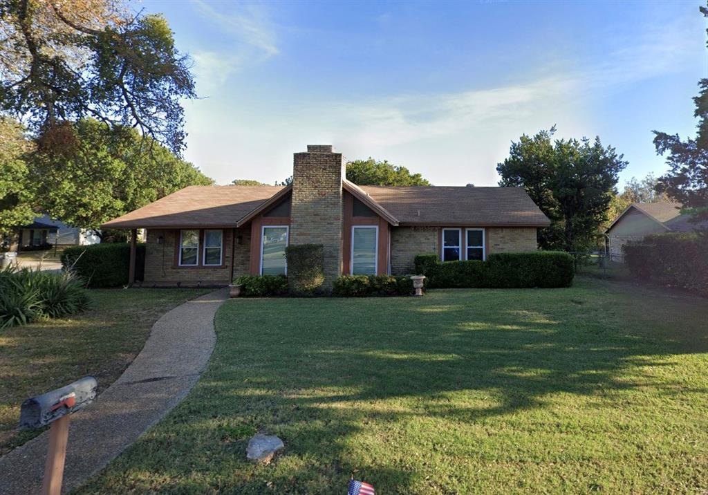 Single story home with a chimney and brick siding