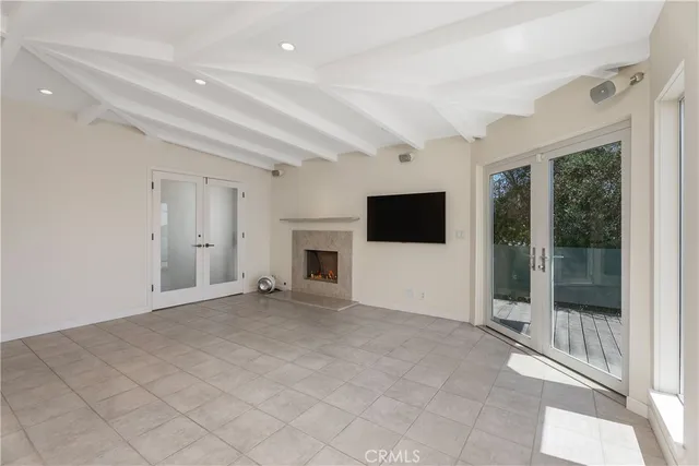 an empty room with windows and fireplace