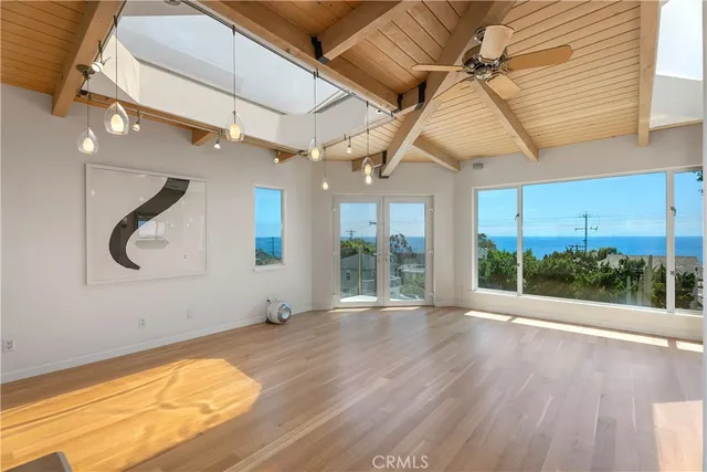 a view of a livingroom with wooden floor and a ceiling fan