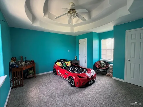 a bedroom with a bed and a chandelier fan