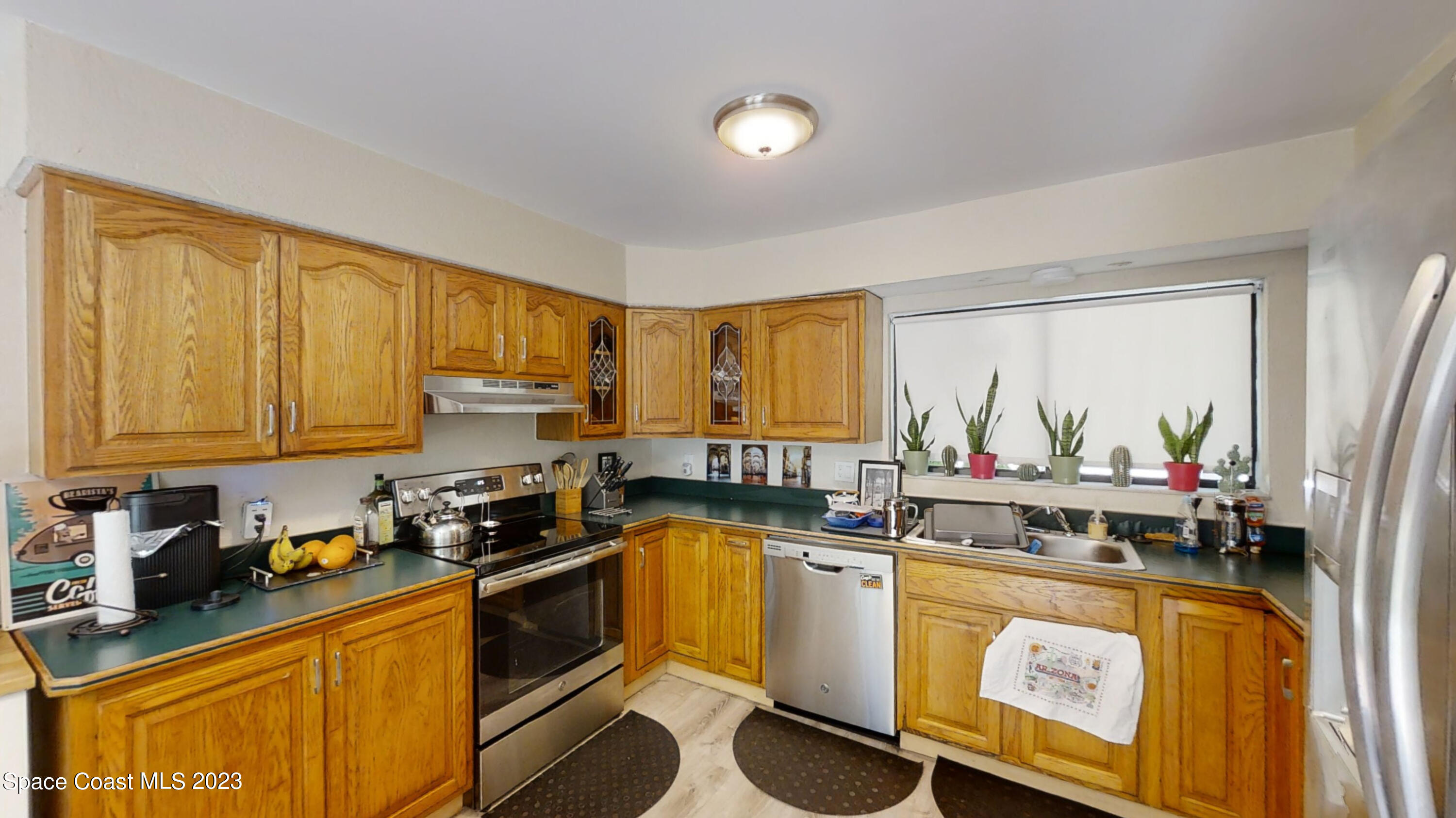 295 Bayhead Drive Melbourne, FL 32940 - Photo 11 of 19 a kitchen with stainless steel appliances granite countertop a stove a sink and a refrigerator