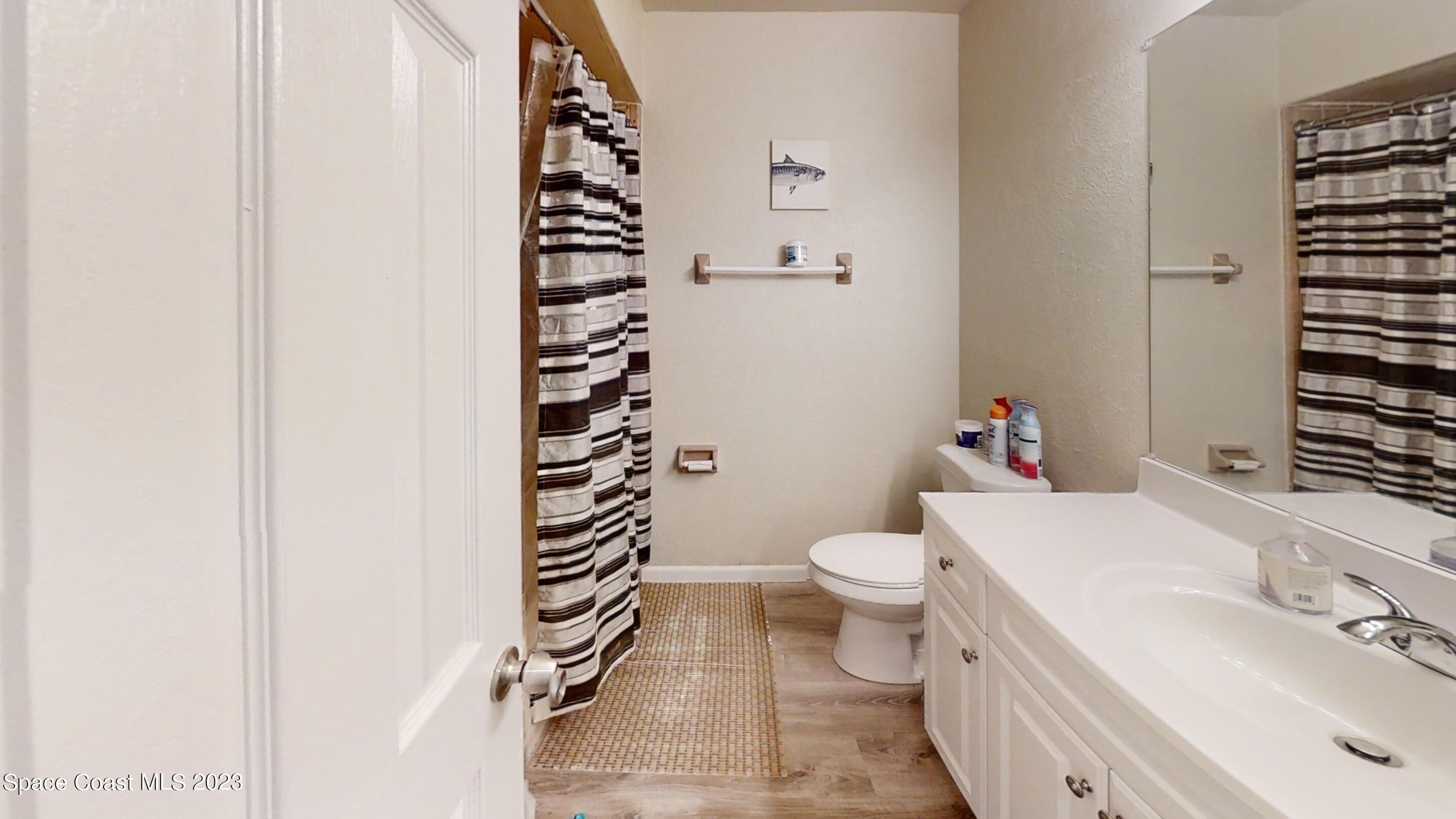 295 Bayhead Drive Melbourne, FL 32940 - Photo 15 of 19 a bathroom with a sink a toilet and shower curtain
