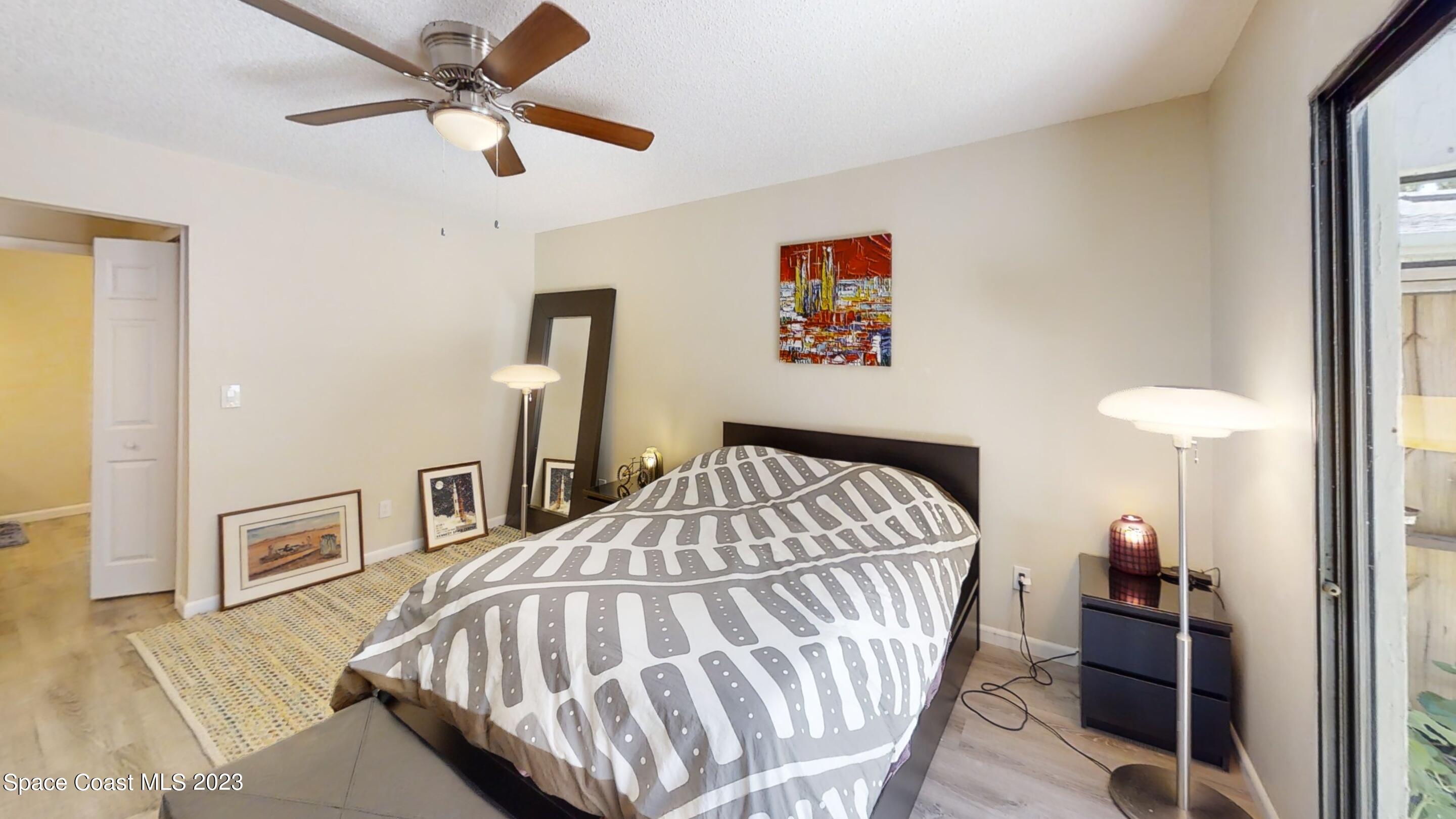 295 Bayhead Drive Melbourne, FL 32940 - Photo 16 of 19 a bedroom with a bed and a chandelier