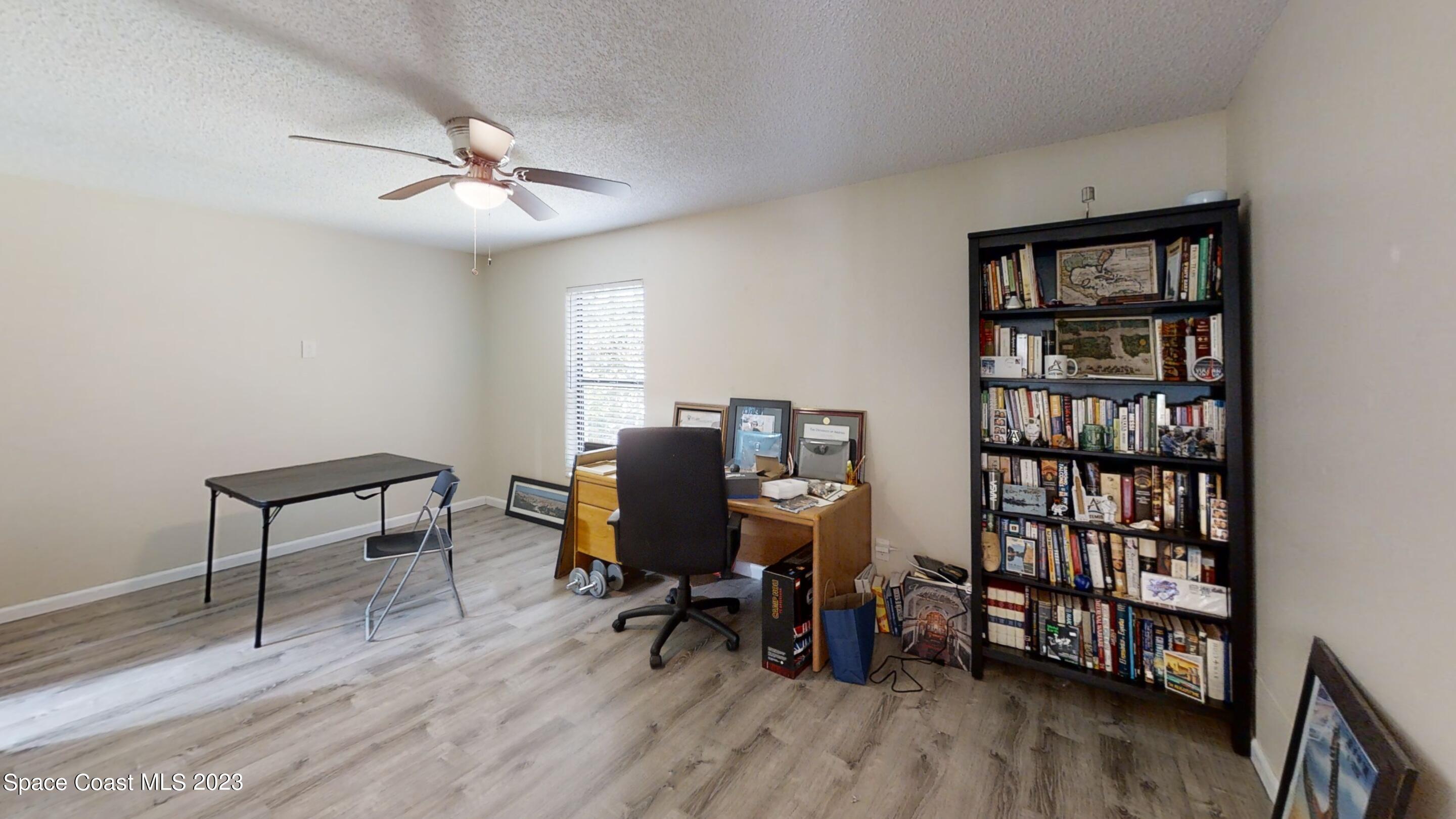 295 Bayhead Drive Melbourne, FL 32940 - Photo 17 of 19 a view of a workspace with furniture and wooden floor