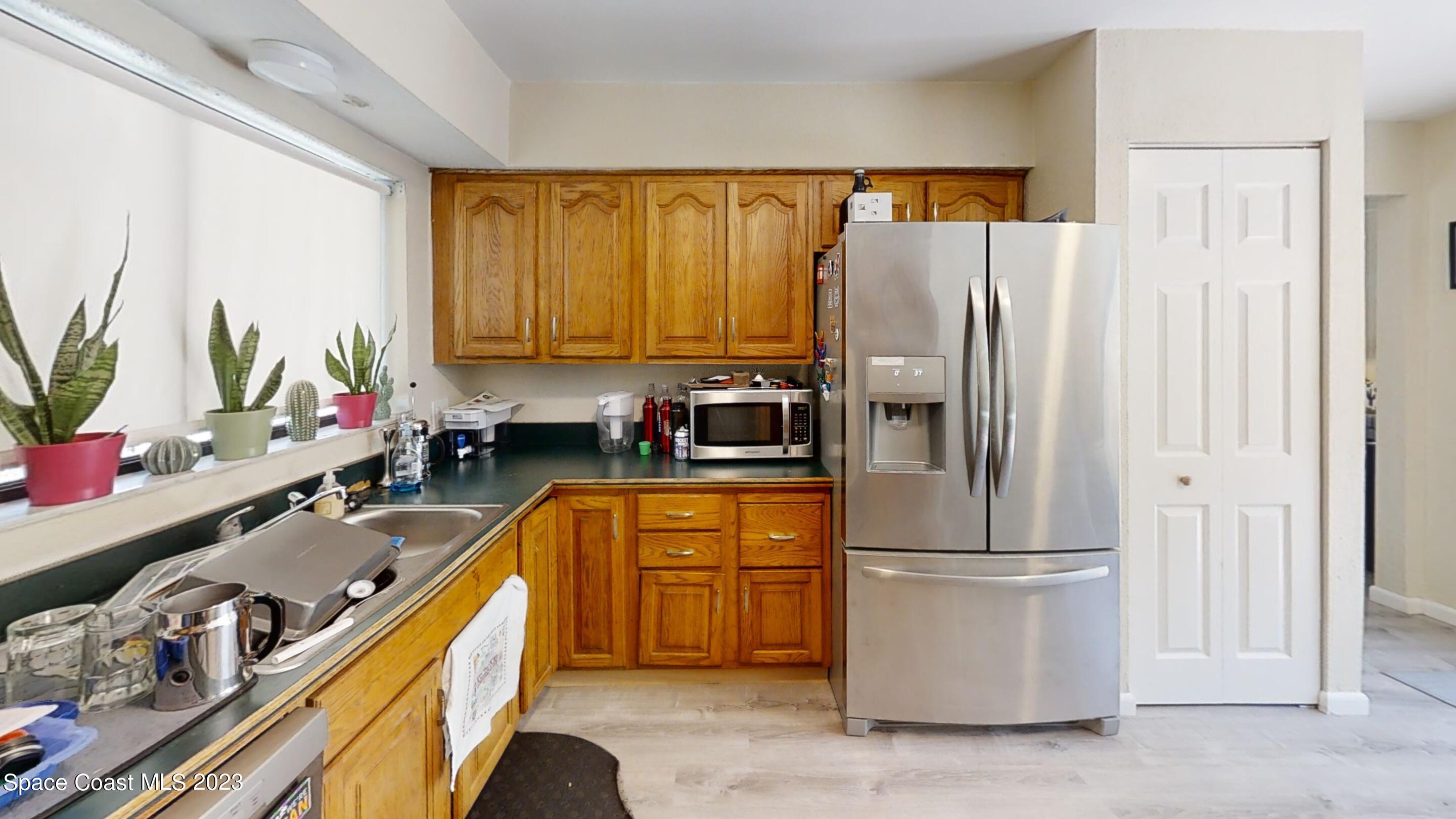 295 Bayhead Drive Melbourne, FL 32940 - Photo 10 of 19 a kitchen with a refrigerator a sink and cabinets