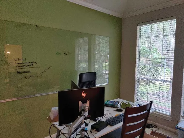 a view of a workspace with furniture and a window