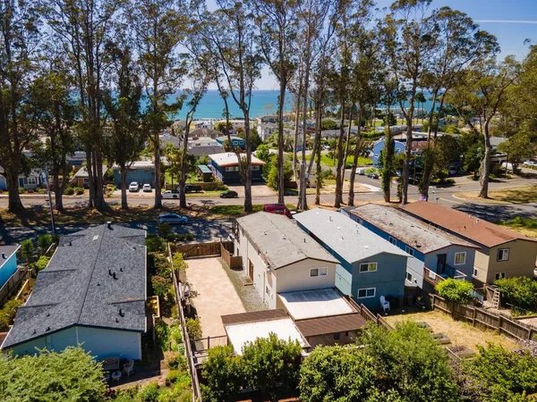 an aerial view of a residential apartment building with a yard and parking spaces