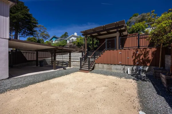 a view of a house with a wooden deck and a backyard