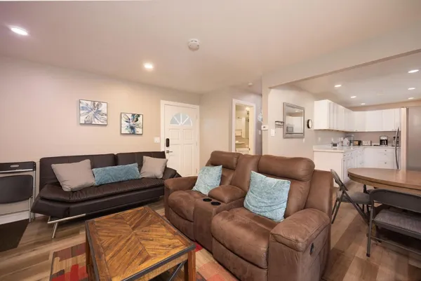 a living room with furniture and a view of kitchen