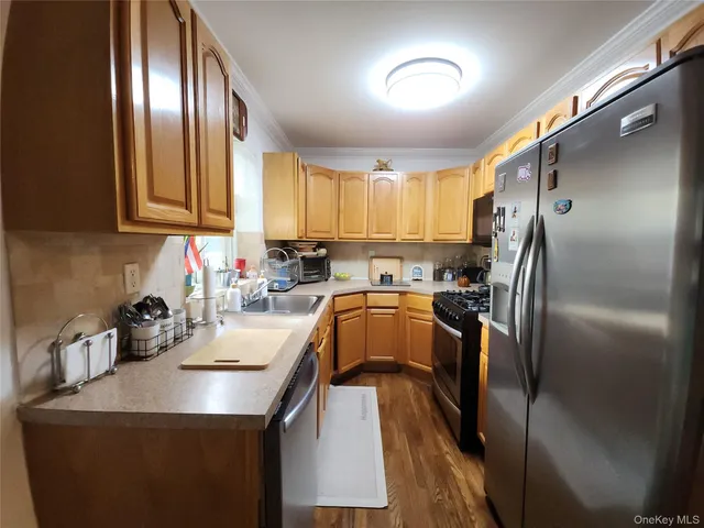 a kitchen with a sink a refrigerator and cabinets