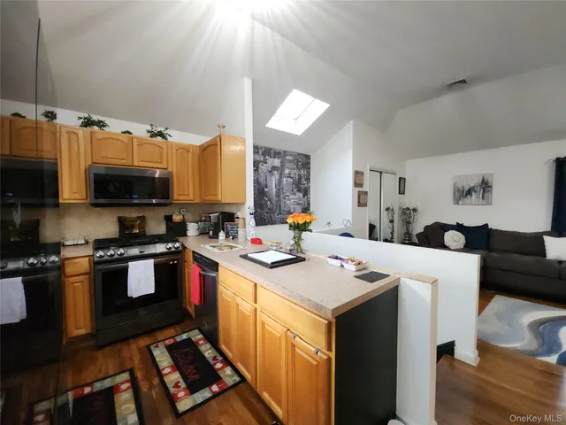 a kitchen with stainless steel appliances a stove sink microwave and cabinets