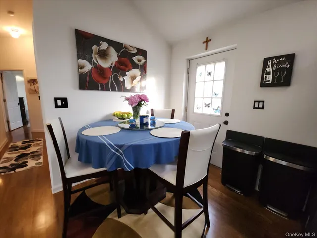 a view of a dining room with furniture a kitchen and wooden floor