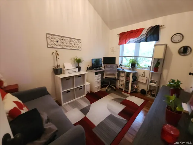 a living room with furniture a rug and a floor to ceiling window
