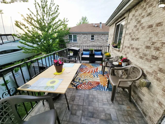 a view of a patio with table and chairs with wooden floor and fence