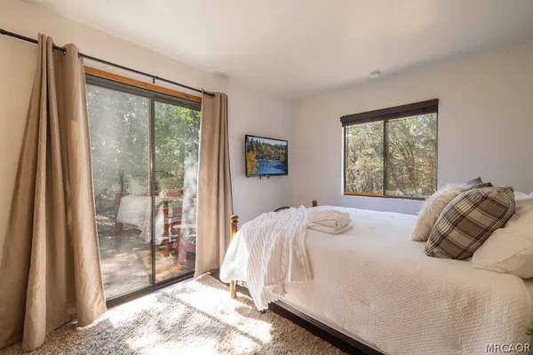 a bedroom with a bed and a large window