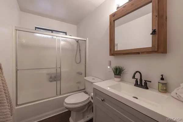 a bathroom with a sink a mirror a toilet and a shower