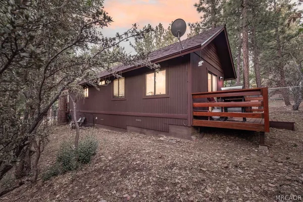 a backyard of a house with barbeque oven and trees