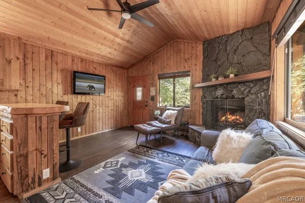 a living room with furniture a flat screen tv and a fireplace