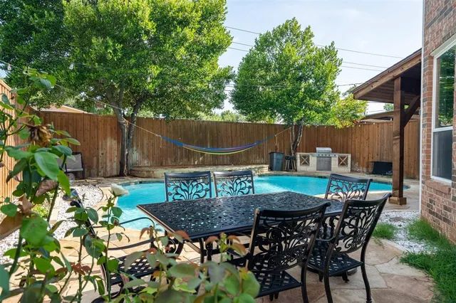 a backyard of a house with table and chairs