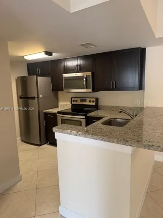 a kitchen with a refrigerator sink and stove