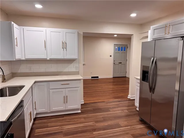a kitchen with stainless steel appliances granite countertop a refrigerator sink and cabinets