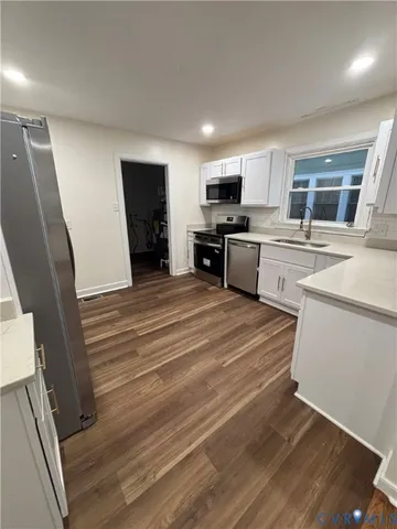 a large white kitchen with sink stove and refrigerator