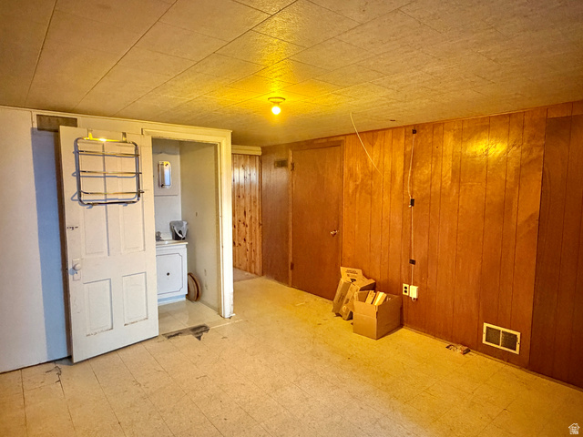 196 North 5th West Price, UT 84501 - Photo 21 of 27 Interior space featuring wood-panel walls, a drop ceiling, and light-colored flooring