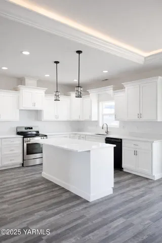 a large kitchen with stainless steel appliances kitchen island granite countertop a stove a sink and white cabinets