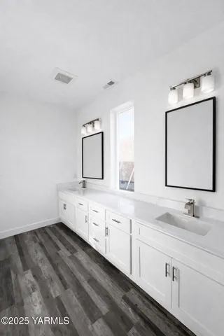 a bathroom with a double vanity sink and mirror