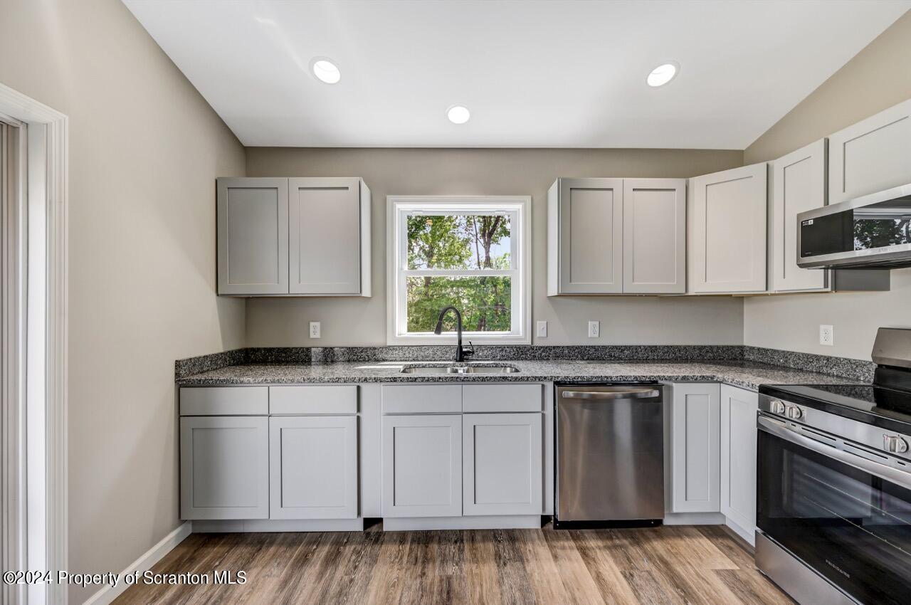 551 Back Street Scranton, PA 18504 - Photo 17 of 47 a kitchen with granite countertop white cabinets stainless steel appliances a sink and a window