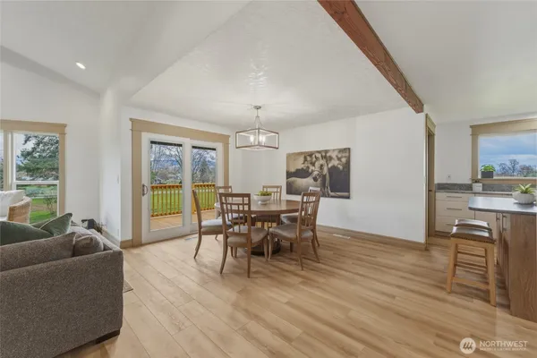 a kitchen with a sink a stove a refrigerator and white cabinets with wooden floor