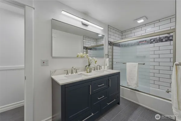 a bathroom with a sink mirror and a shower