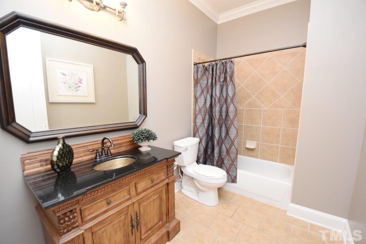 10320 Old Creedmoor Road Raleigh, NC 27613 - Photo 23 of 25 a bathroom with a granite countertop sink a toilet and a mirror