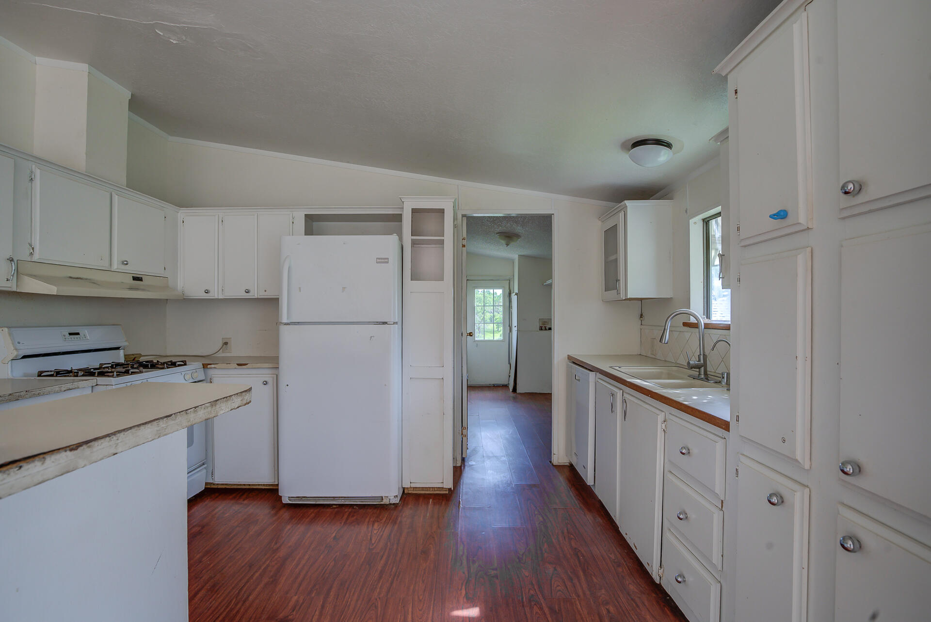 4450 Locust Road Anderson, CA 96007 - Photo 14 of 40 a kitchen with white cabinets and white appliances