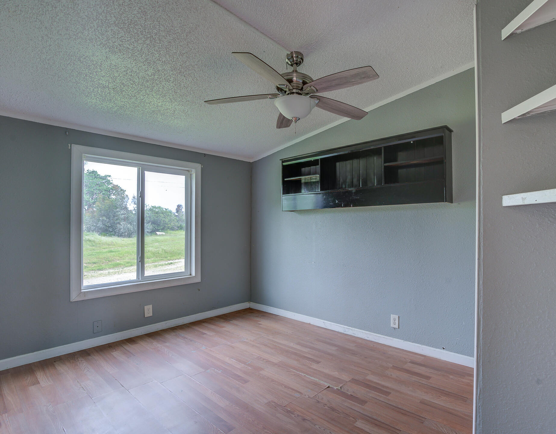 4450 Locust Road Anderson, CA 96007 - Photo 23 of 40 a view of an empty room with a window and wooden floor
