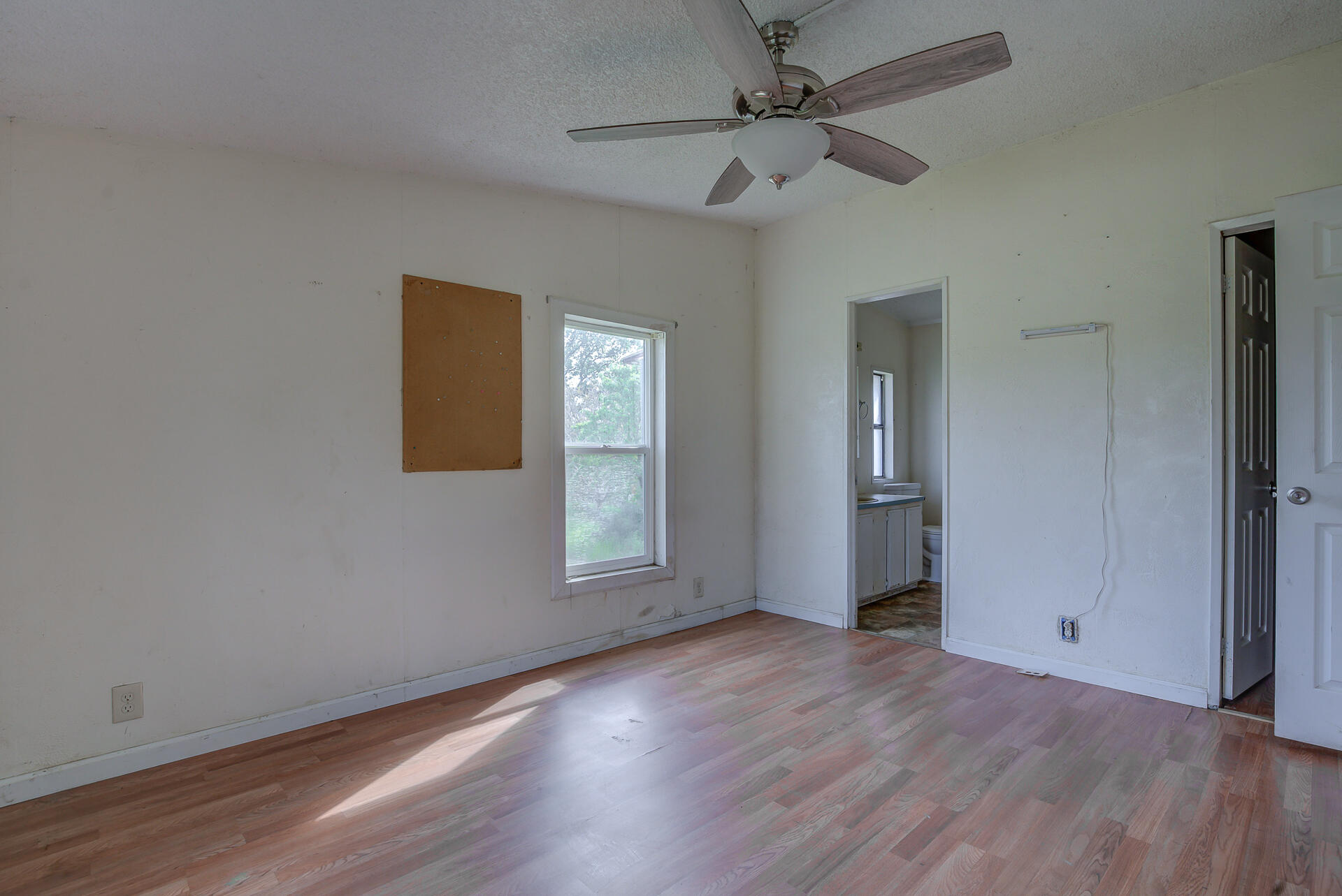 4450 Locust Road Anderson, CA 96007 - Photo 29 of 40 an empty room with wooden floor chandelier fan and windows