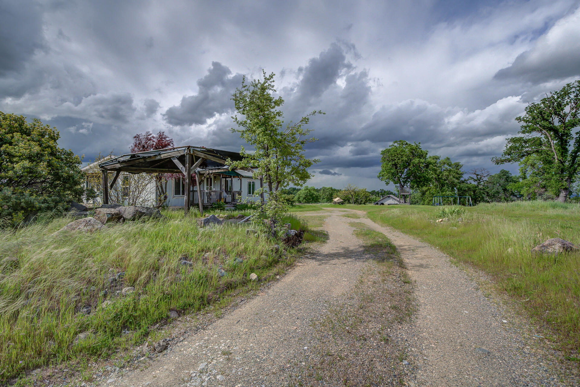 4450 Locust Road Anderson, CA 96007 - Photo 3 of 40 a backyard of a house with a garden and barbeque oven