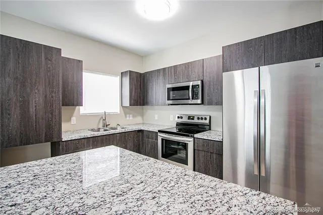 a kitchen with a refrigerator stove and sink