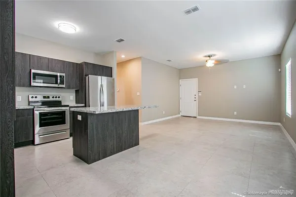 a kitchen with stainless steel appliances a refrigerator and a stove top oven