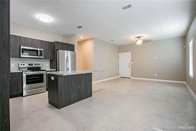 a kitchen with stainless steel appliances a refrigerator and a stove top oven