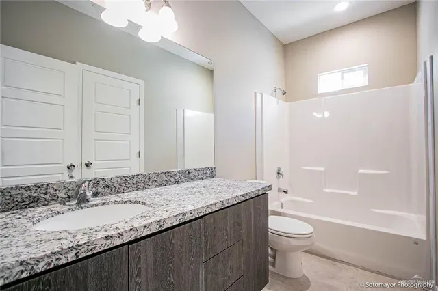 a view of a hallway with wooden floor and closet area